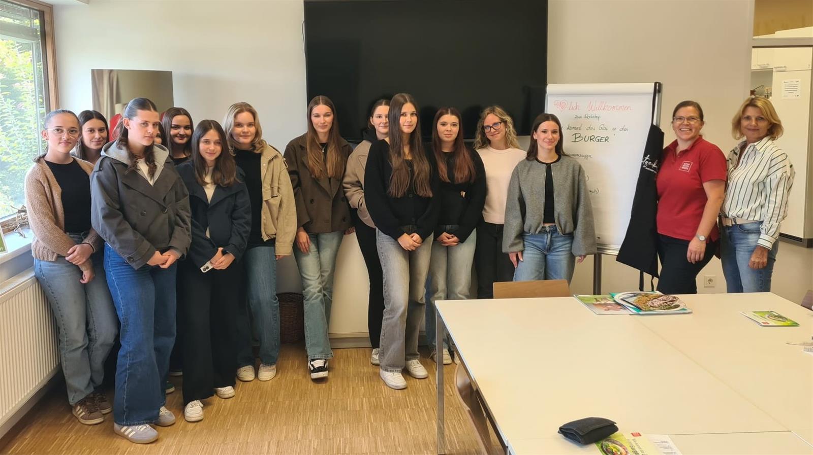 Schülerinnen und Lehrerinnen stehen vor einer Tafel in einem Workshop in Österreich.